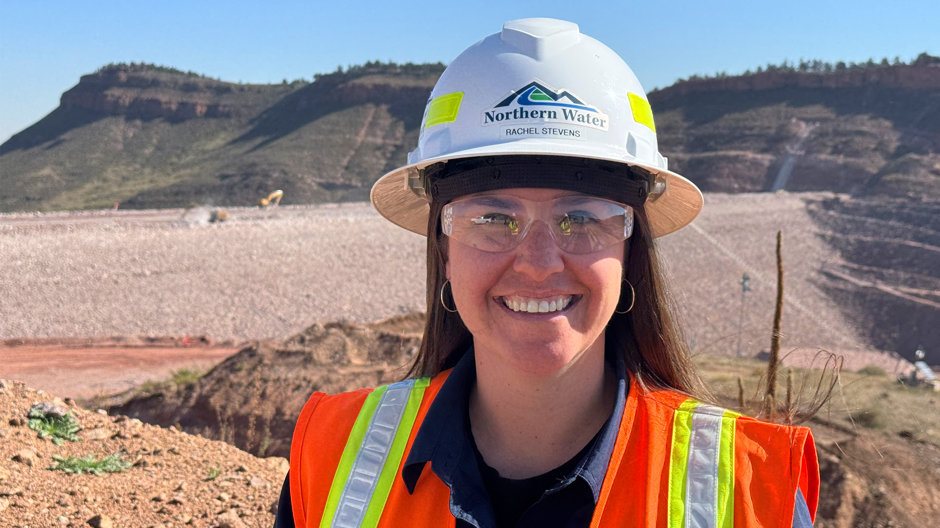 Rachel Stevens in PPE in front of main dam at Chimney Hollow