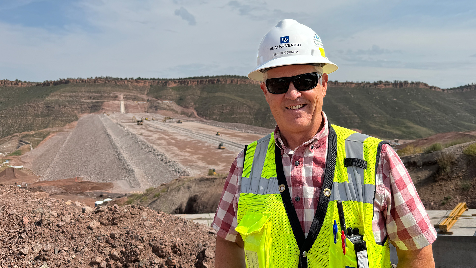 Bill McCormick with view of main dam behind him