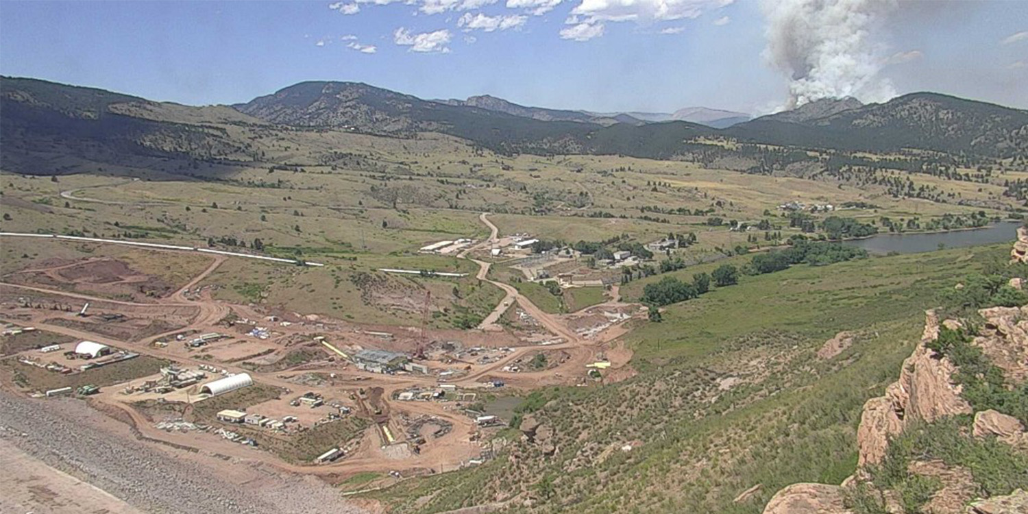 View of Chimney Hollow Reservoir with smoke from the Alexander Mountain fire in the distance.