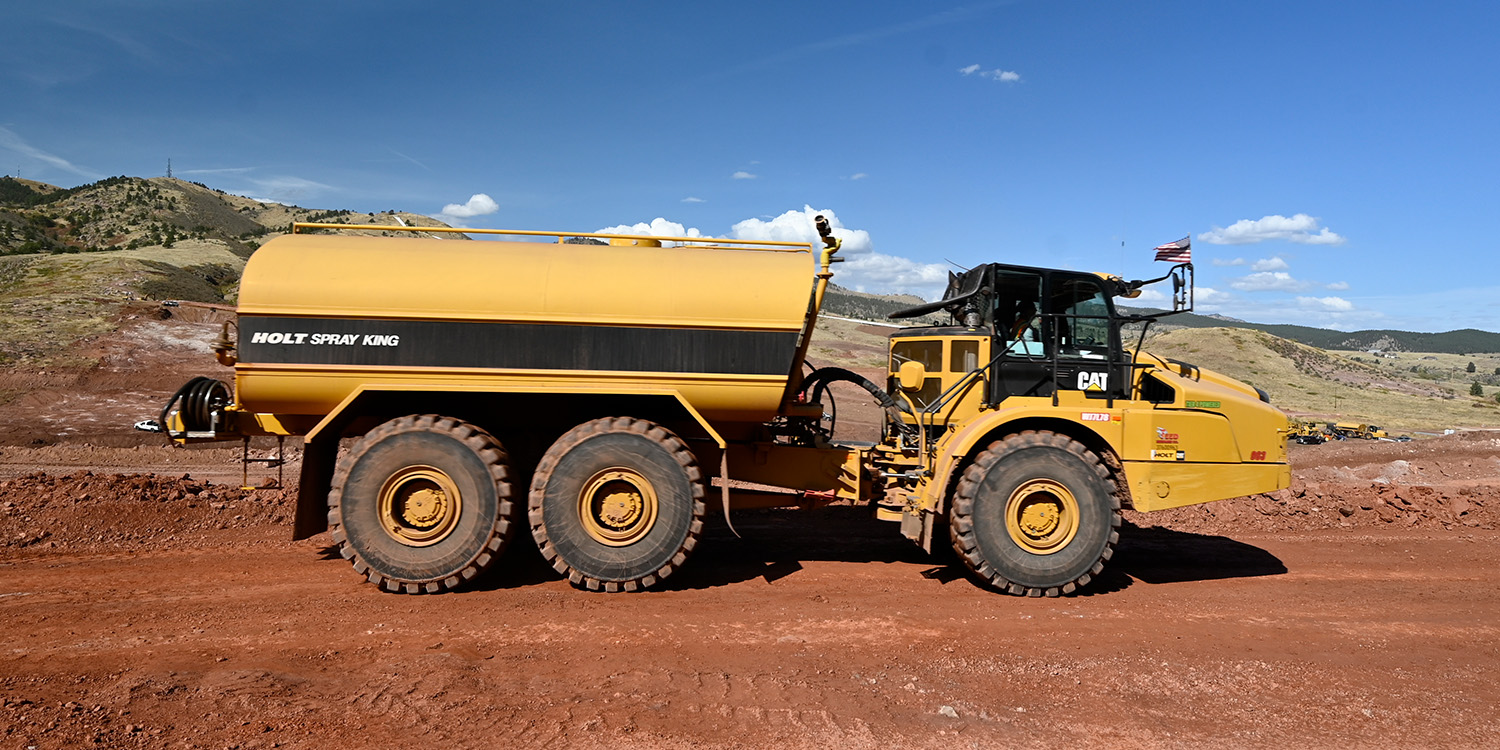 Parked yellow water truck.